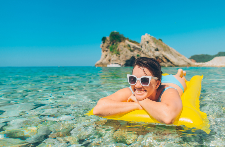 A photo of a woman in the water on a pool float.